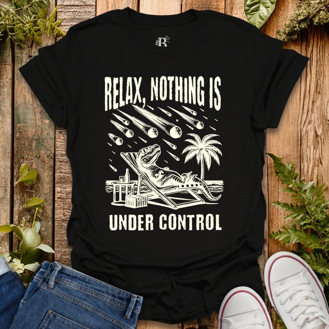 Black t-shirt with white graphic and text 'Relax, Nothing is Under Control' on a wooden background.