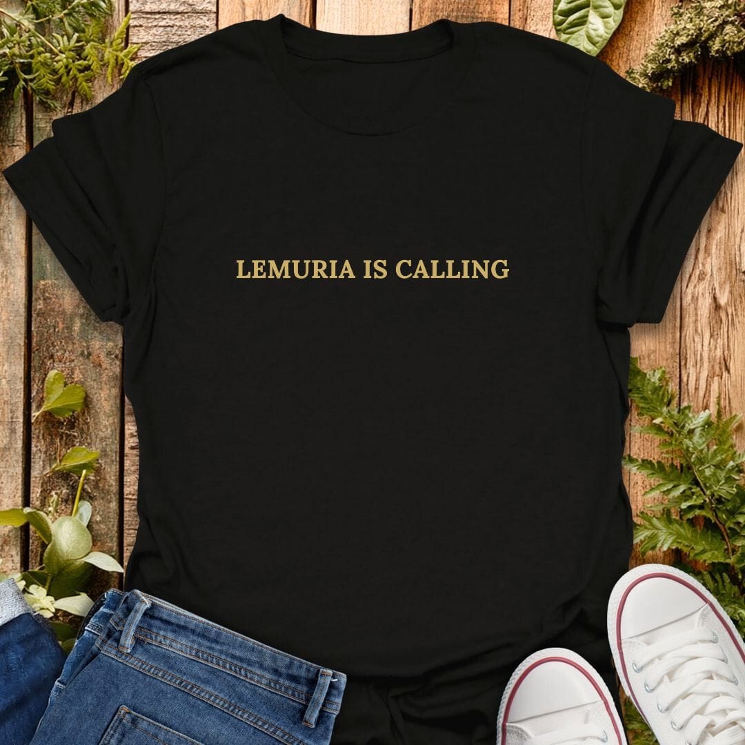 Black t-shirt with 'Lemuria is calling' text on a wooden surface with plants, jeans and sneakers.