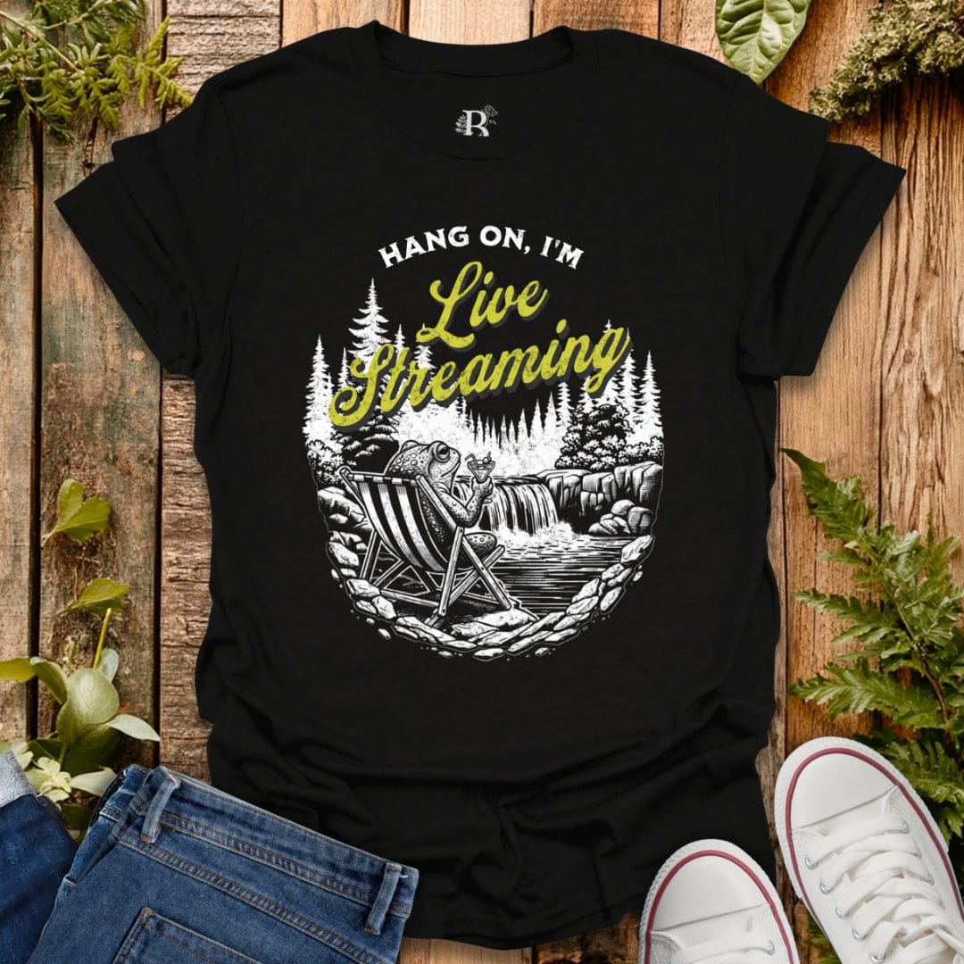 Black t-shirt with 'Hang on, I'm Live Streaming' graphic design on a wooden background