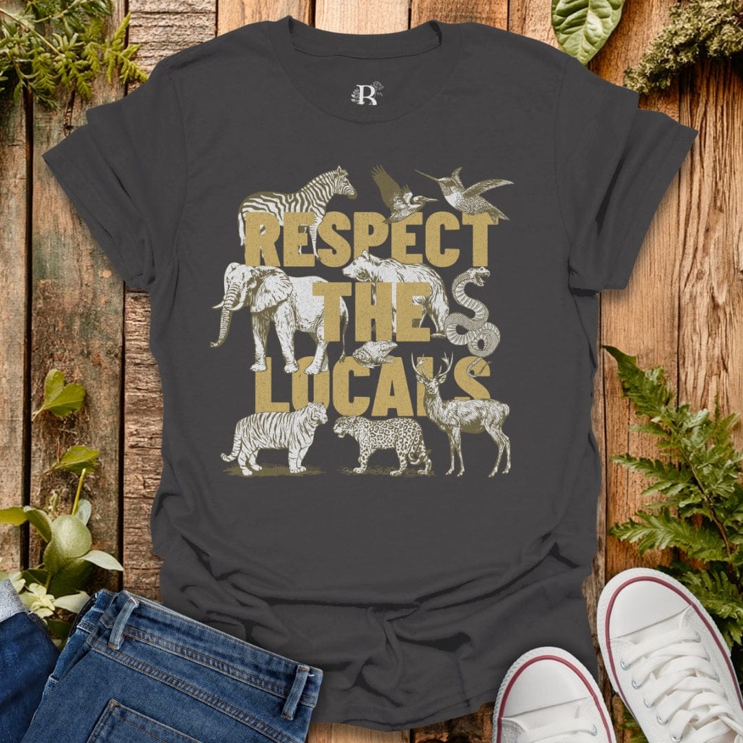 Gray t-shirt with animal graphics and 'Respect the Lucals' text on a wooden surface with plants.