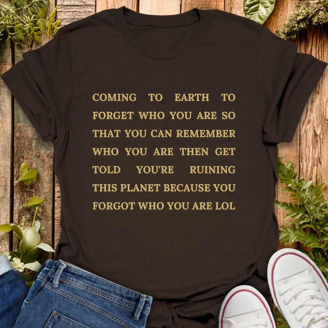 brown t-shirt with text "coming to earth to forget who you are so that you can remember who you are then get told you're ruining this planet because you forgot who you are LOL".
