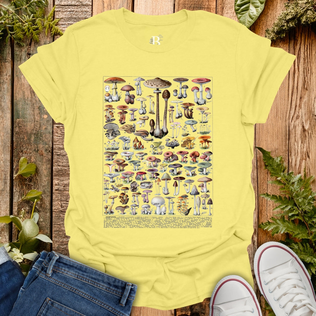 Yellow t-shirt with mushroom design on a wooden surface with plants.