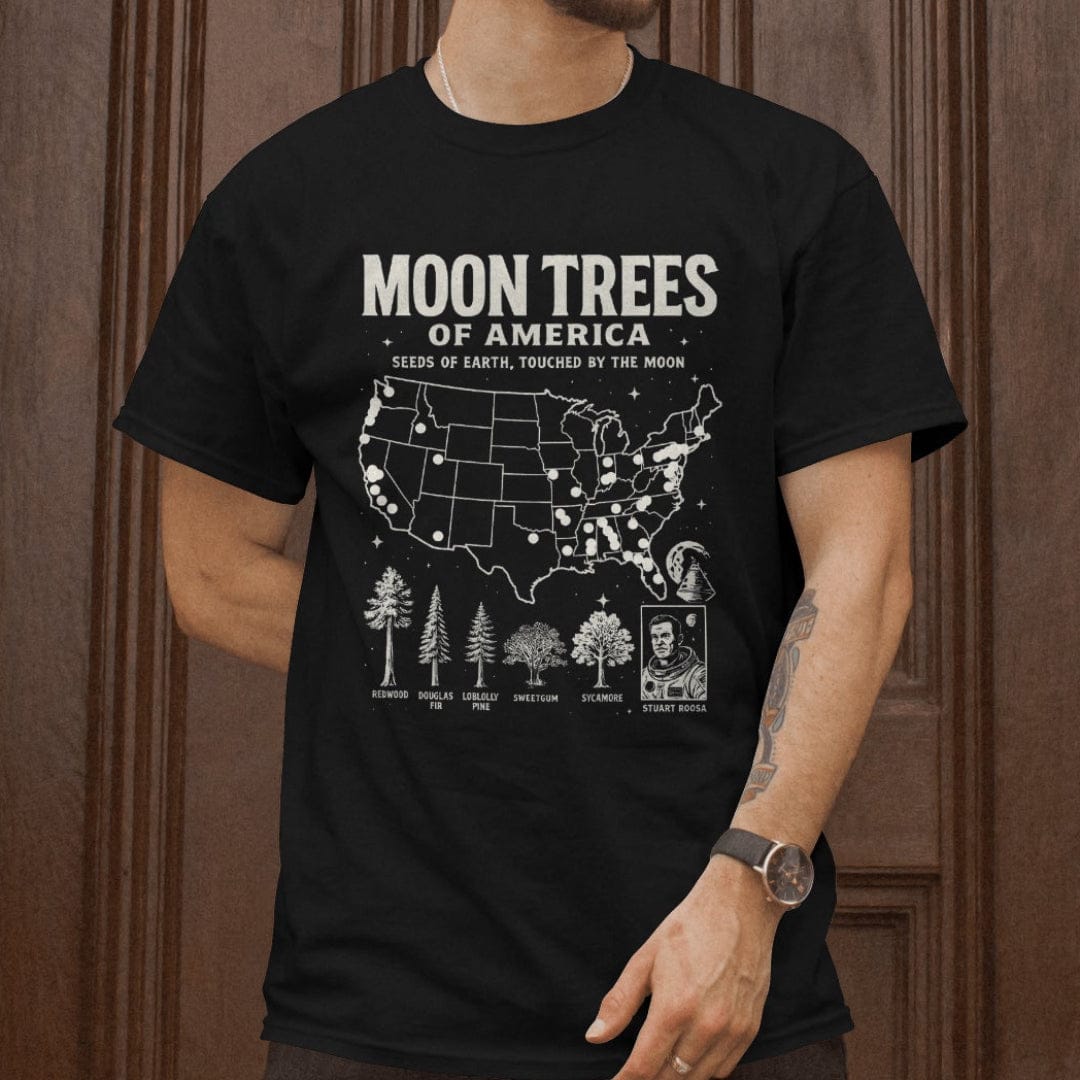 Man wearing black t-shirt with ‘Moon Trees of America’ text, and a map of the locations of moon trees, and a comic style photo of astronaut  Stuart Roosa. 