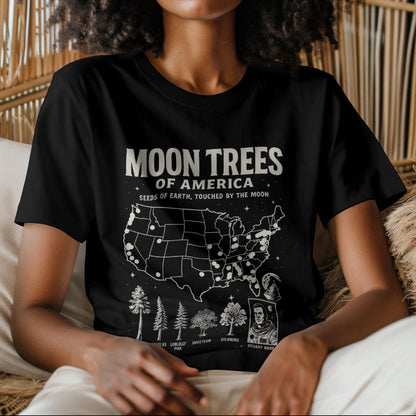 Woman wearing black t-shirt with ‘Moon Trees of America’ text, and a map of the locations of moon trees, and a comic style photo of astronaut  Stuart Roosa. 