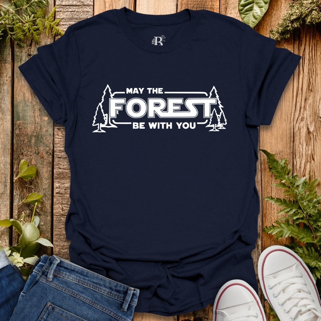Navy blue t-shirt with 'May the Forest Be With You' text on a wooden background with plants.