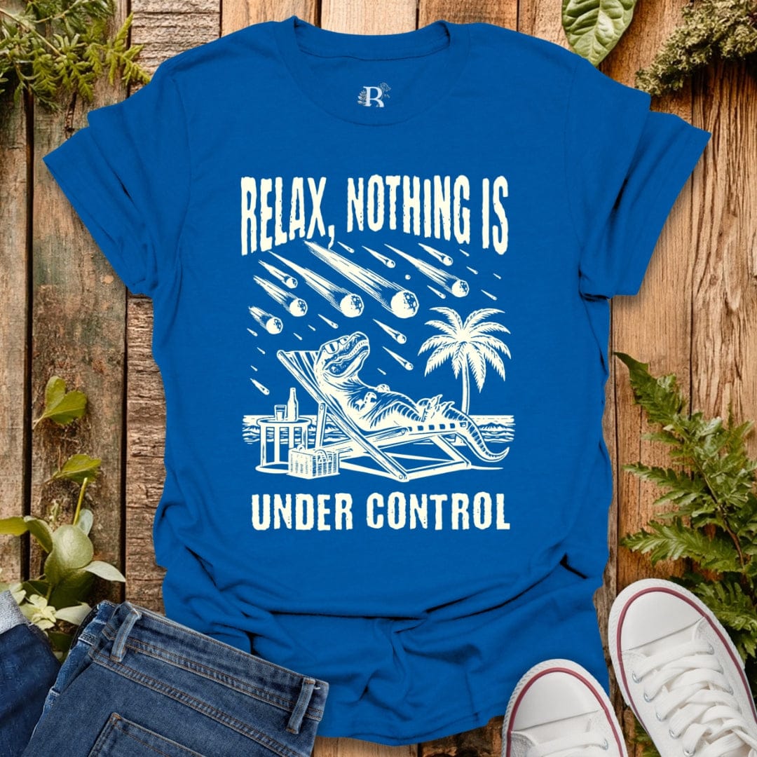 Blue t-shirt with white graphic and text 'Relax, Nothing is Under Control' on a wooden surface.