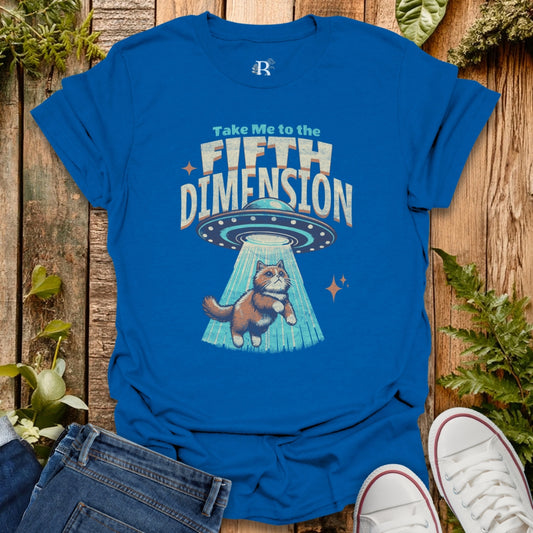 Blue t-shirt with a cat being abducted by a UFO design, text 'Take Me to the Fifth Dimension' on a wooden surface.