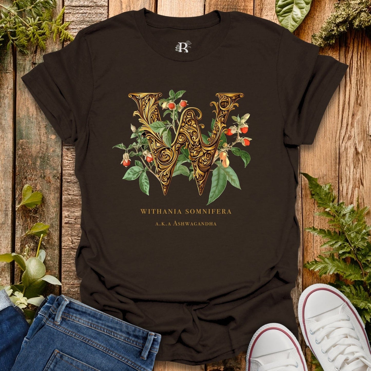 Black t-shirt with decorative letter 'W' design on a wooden surface with plants.