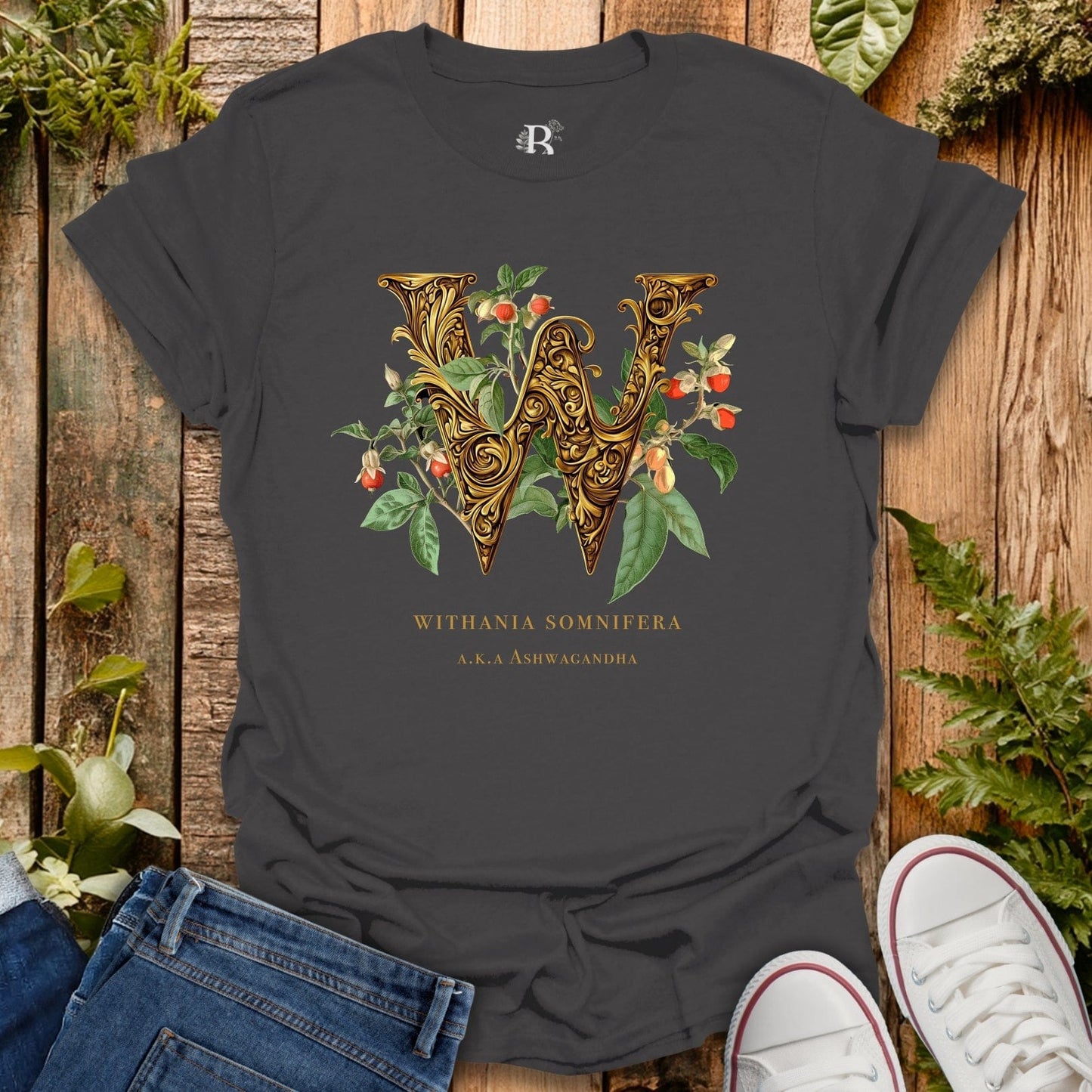 Black t-shirt with decorative letter 'W' design on a wooden surface with plants.