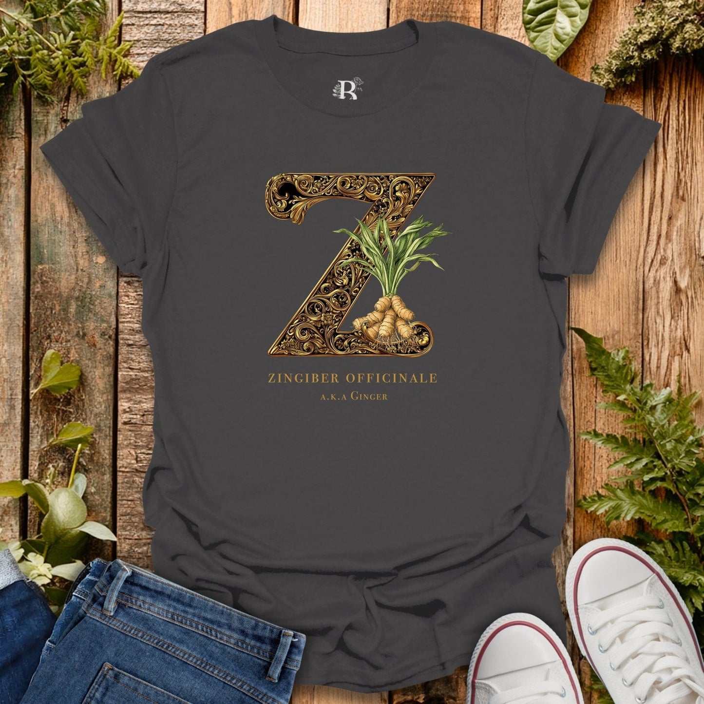 Dark gray t-shirt with decorative letter 'Z' and ginger plant design on a wooden surface with plants.