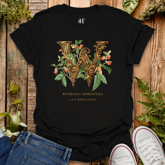 Black t-shirt with decorative letter 'W' design on a wooden surface with plants.