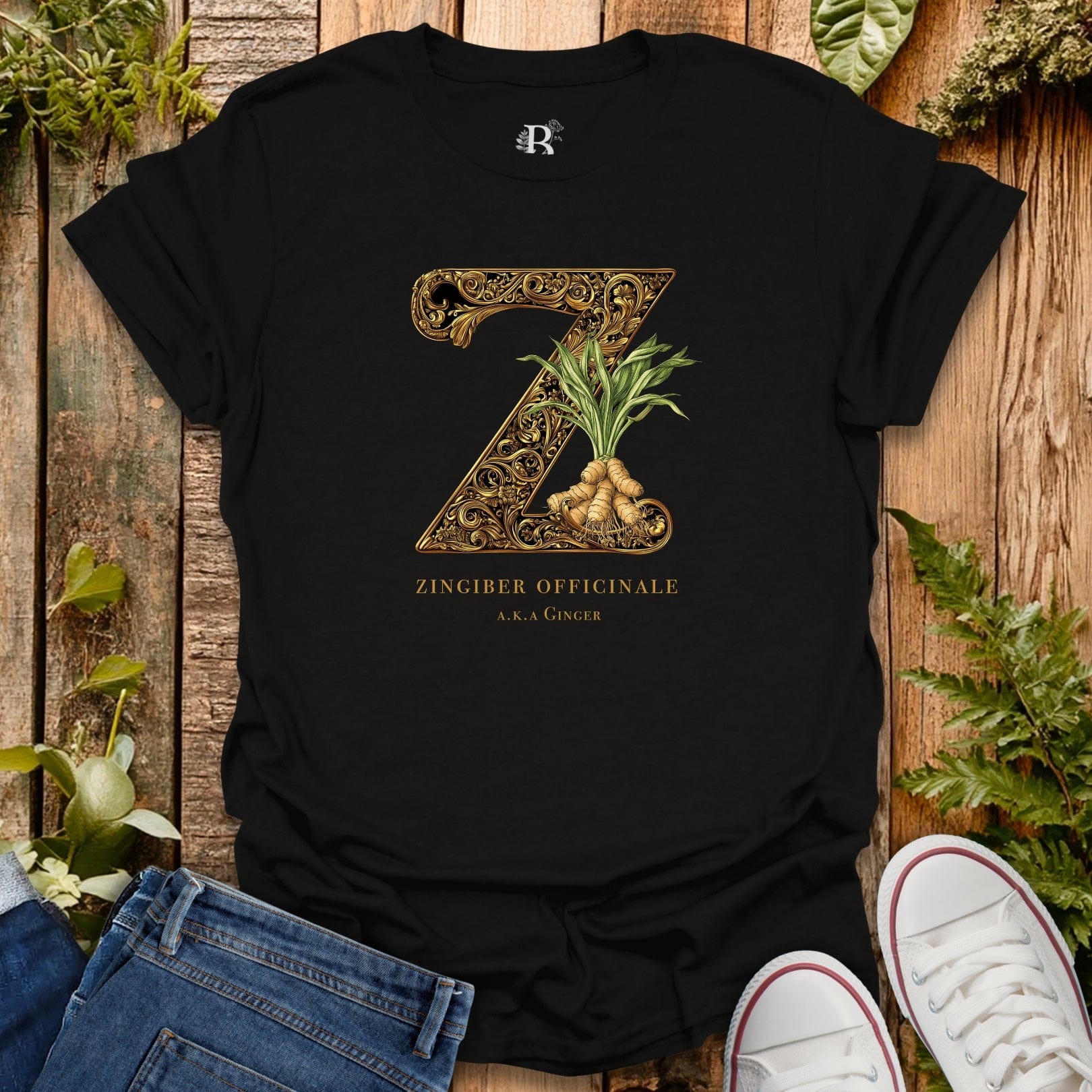 Black t-shirt with decorative 'Z' and ginger plant design on a wooden surface with plants.