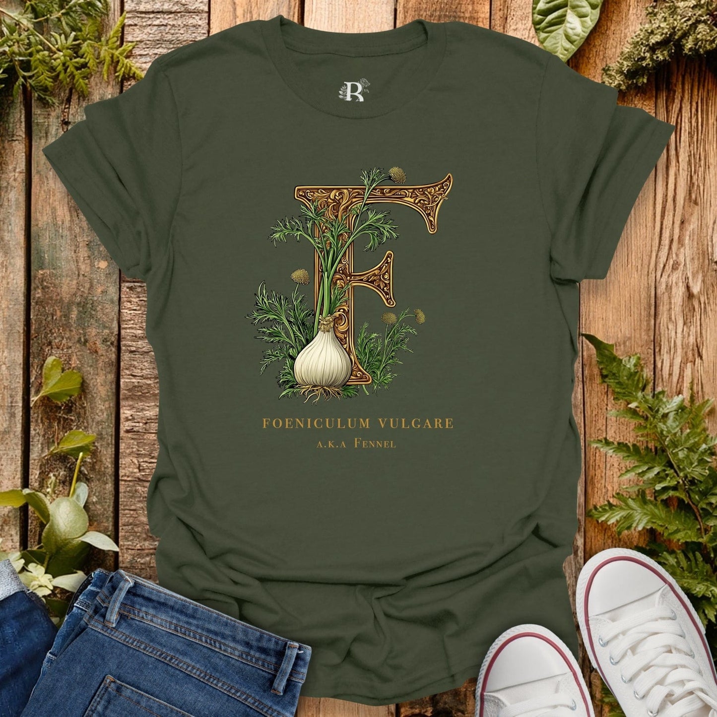 Green t-shirt with botanical design and text on a wooden surface with plants.
