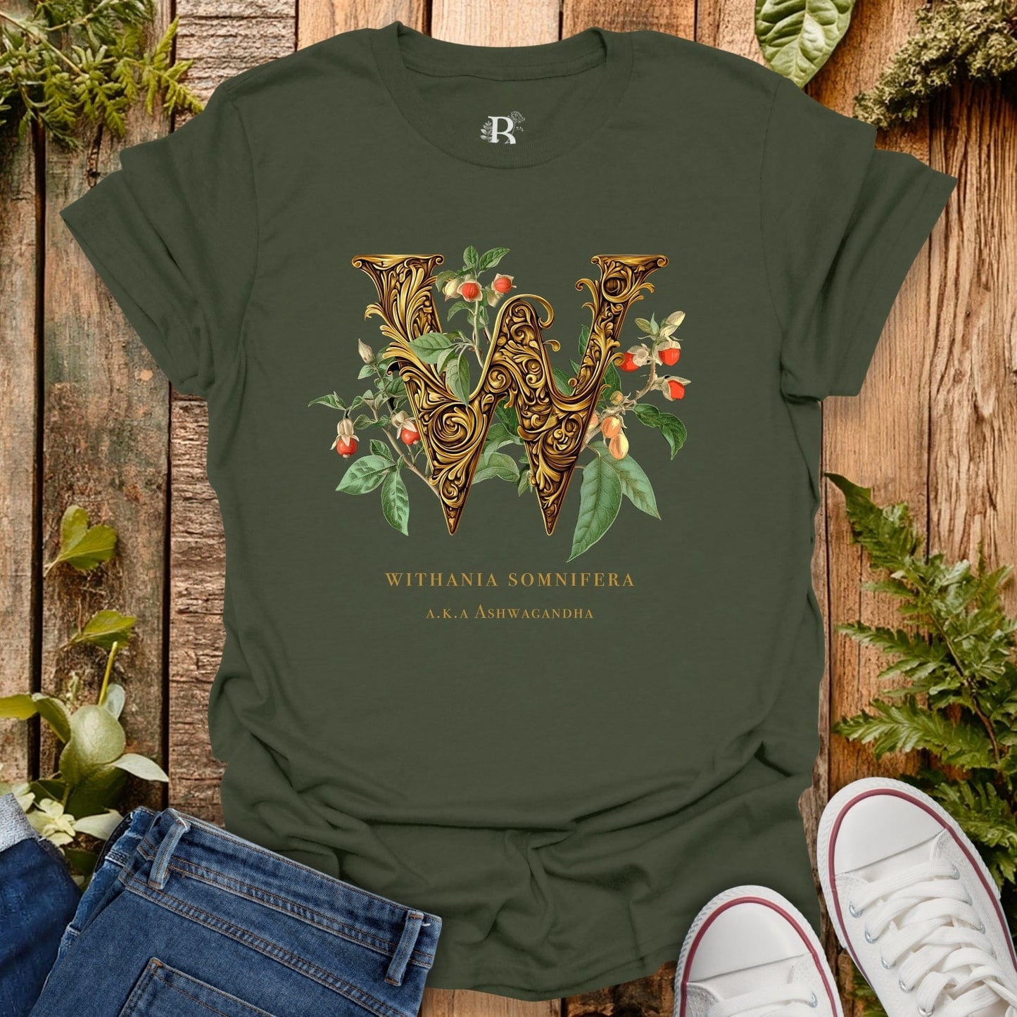 Green t-shirt with decorative letter 'W' design on a wooden surface with plants.
