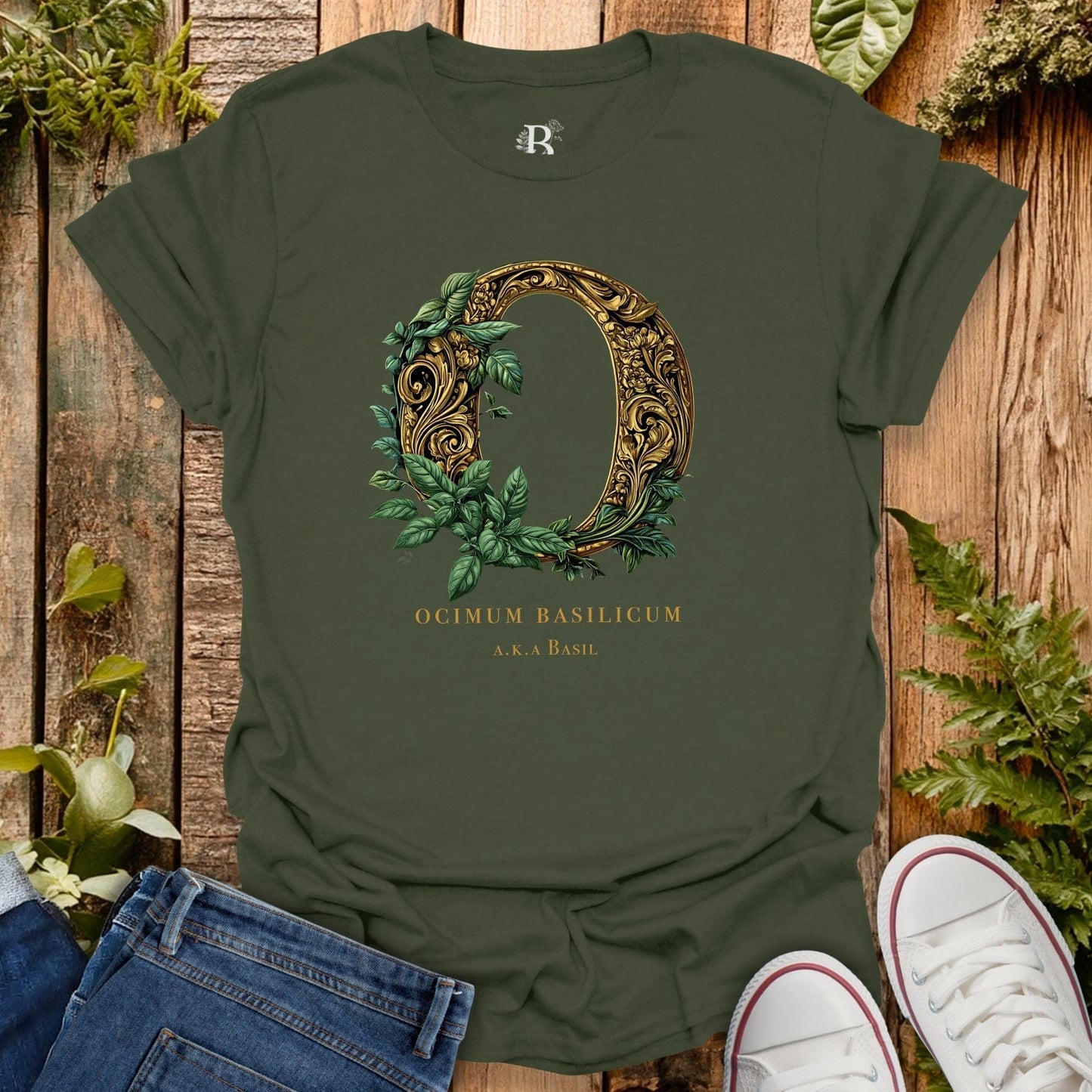 Green t-shirt with decorative letter 'O' design on a wooden surface with plants.