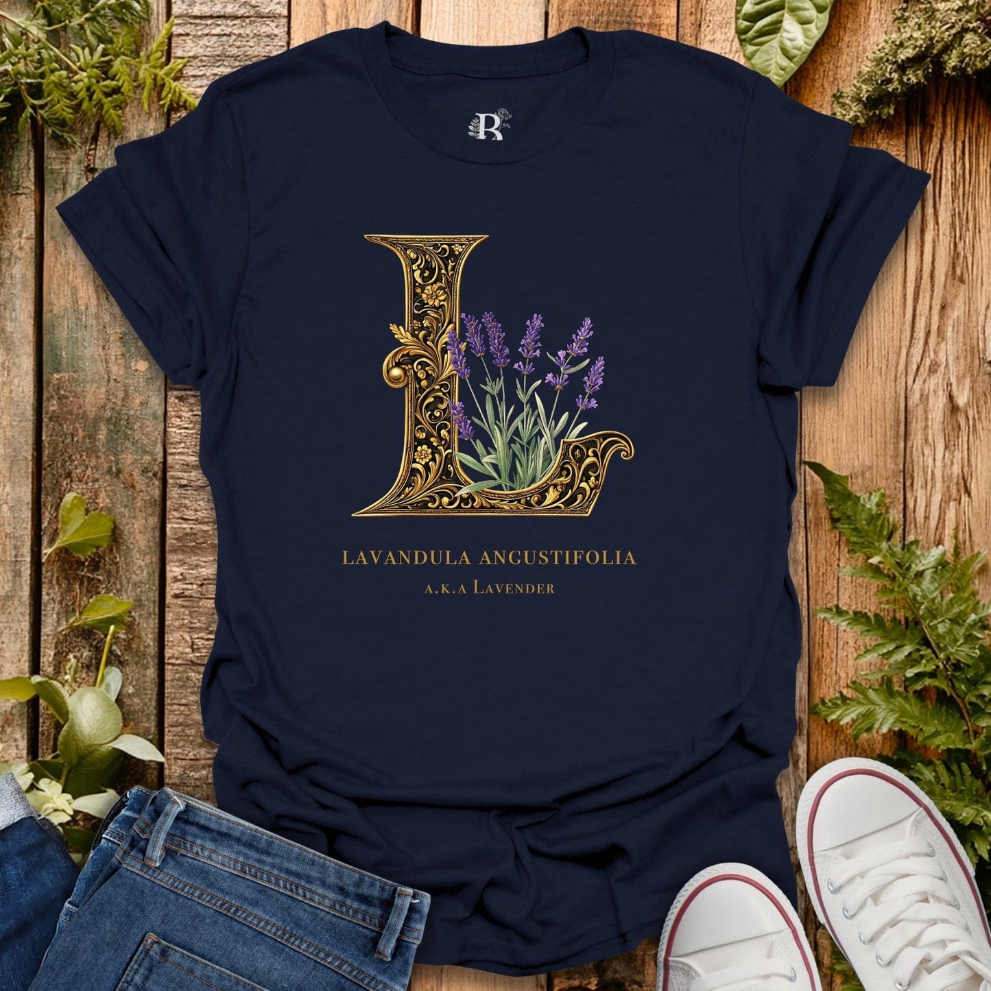 Navy blue t-shirt with decorative 'L' and lavender design on a wooden surface with plants.
