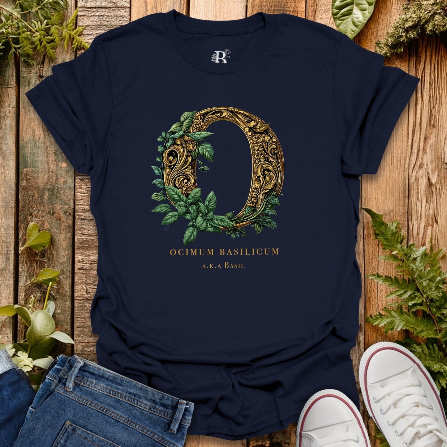 Navy blue t-shirt with decorative letter 'O' design on a wooden surface with plants.