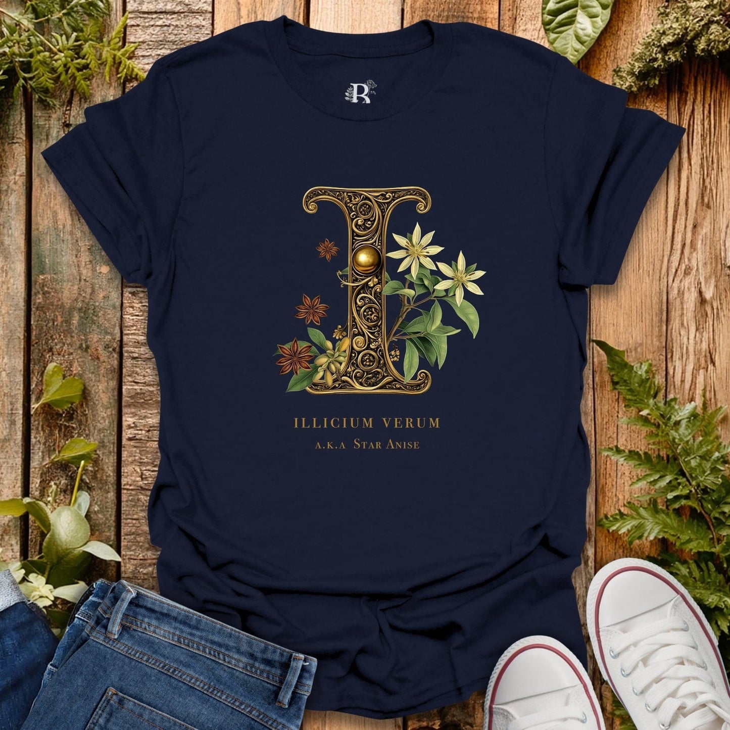 Navy blue t-shirt with decorative letter 'I' design on a wooden surface with plants.