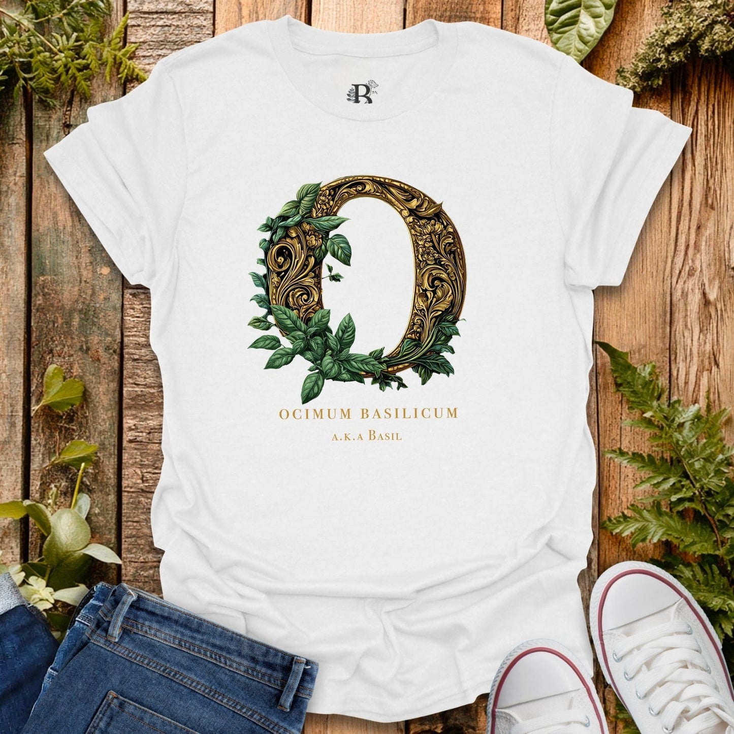 White t-shirt with decorative letter 'Q' design on a wooden surface with plants.