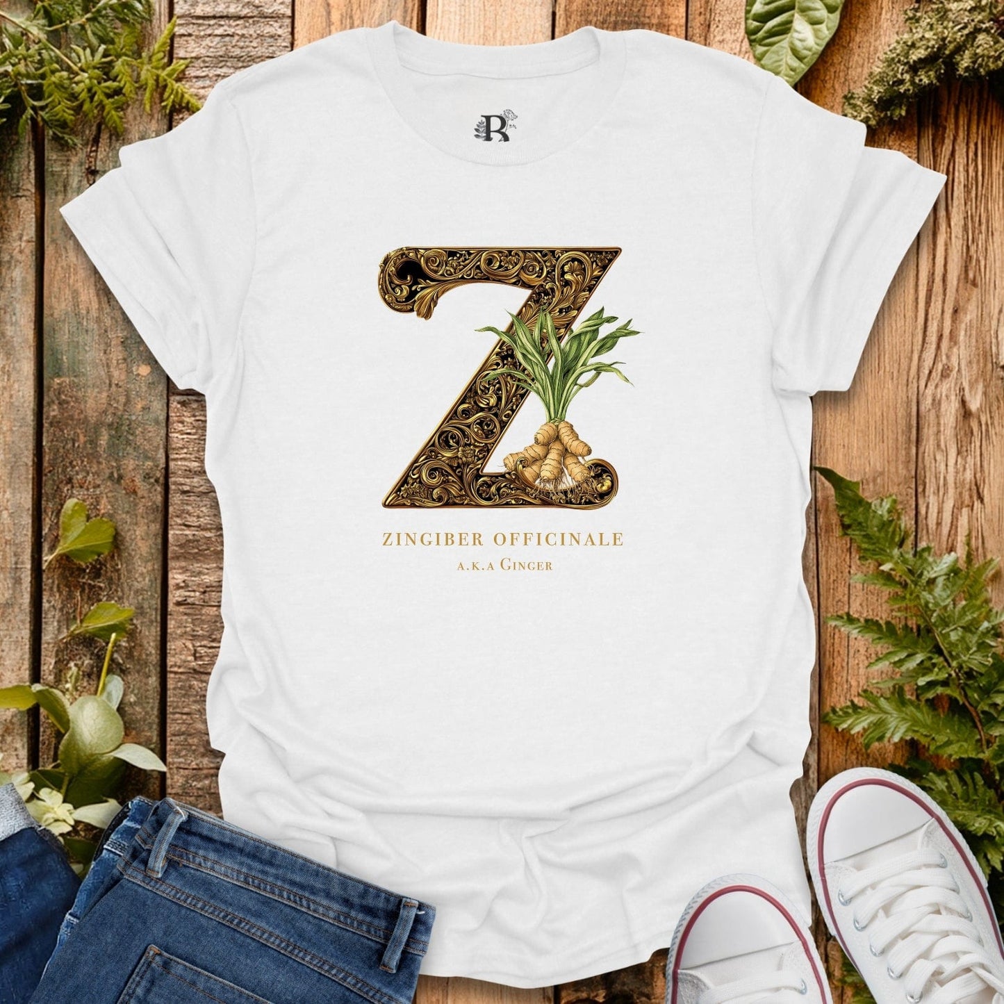 White t-shirt with decorative letter 'Z' and ginger plant design on a wooden surface with plants.