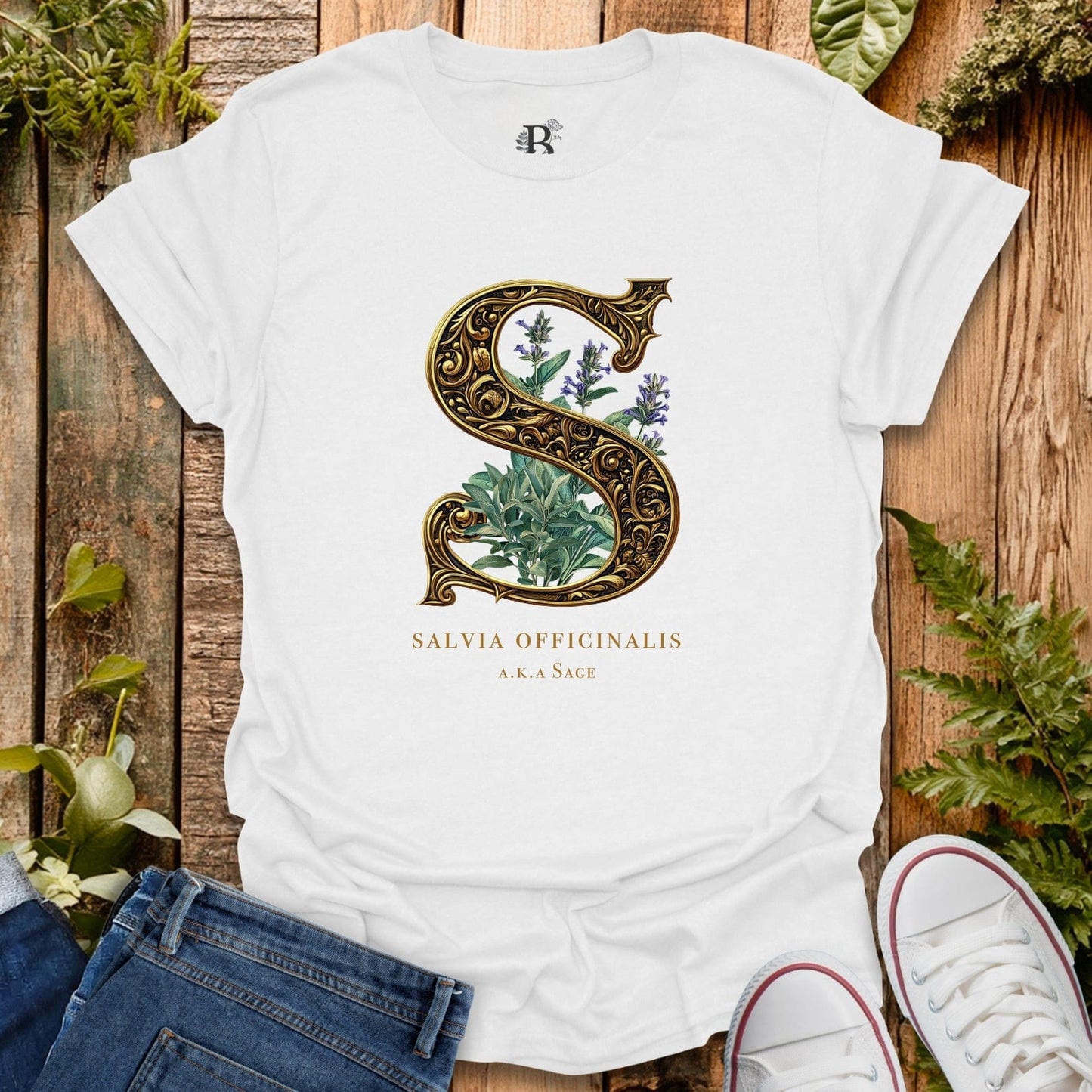 White t-shirt with herbal design and text on a wooden surface with plants.