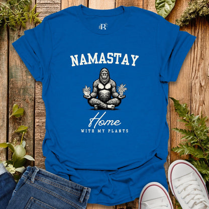 Blue t-shirt with 'Namastay Home with My Plants' design on a wooden background