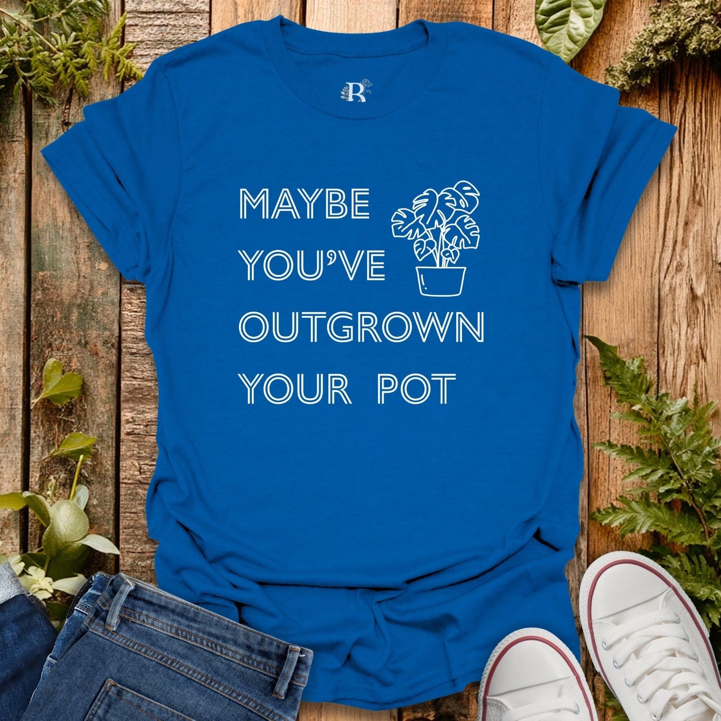 Blue t-shirt with text and plant graphic on a wooden background