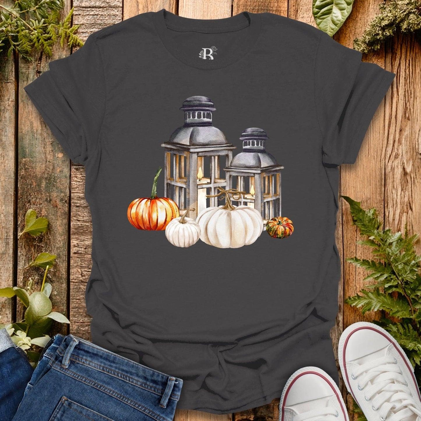 Gray t-shirt with lantern and pumpkins design on a wooden background
