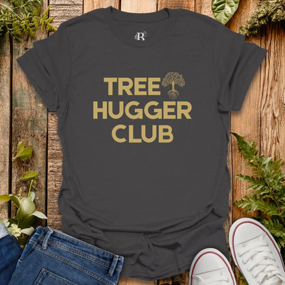Black t-shirt with 'Tree Hugger Club' text on a wooden surface with plants.