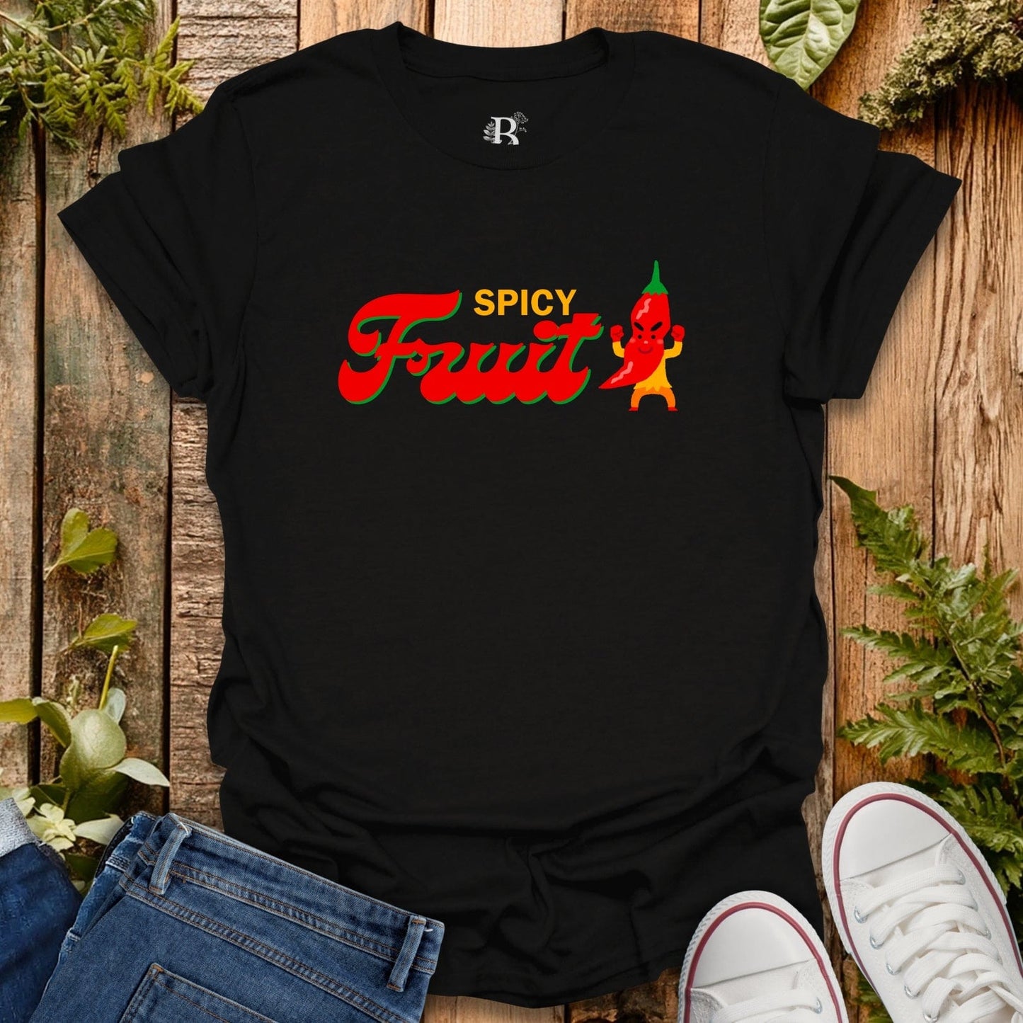Black t-shirt with 'Spicy Fruit' design on a wooden surface with jeans and sneakers.