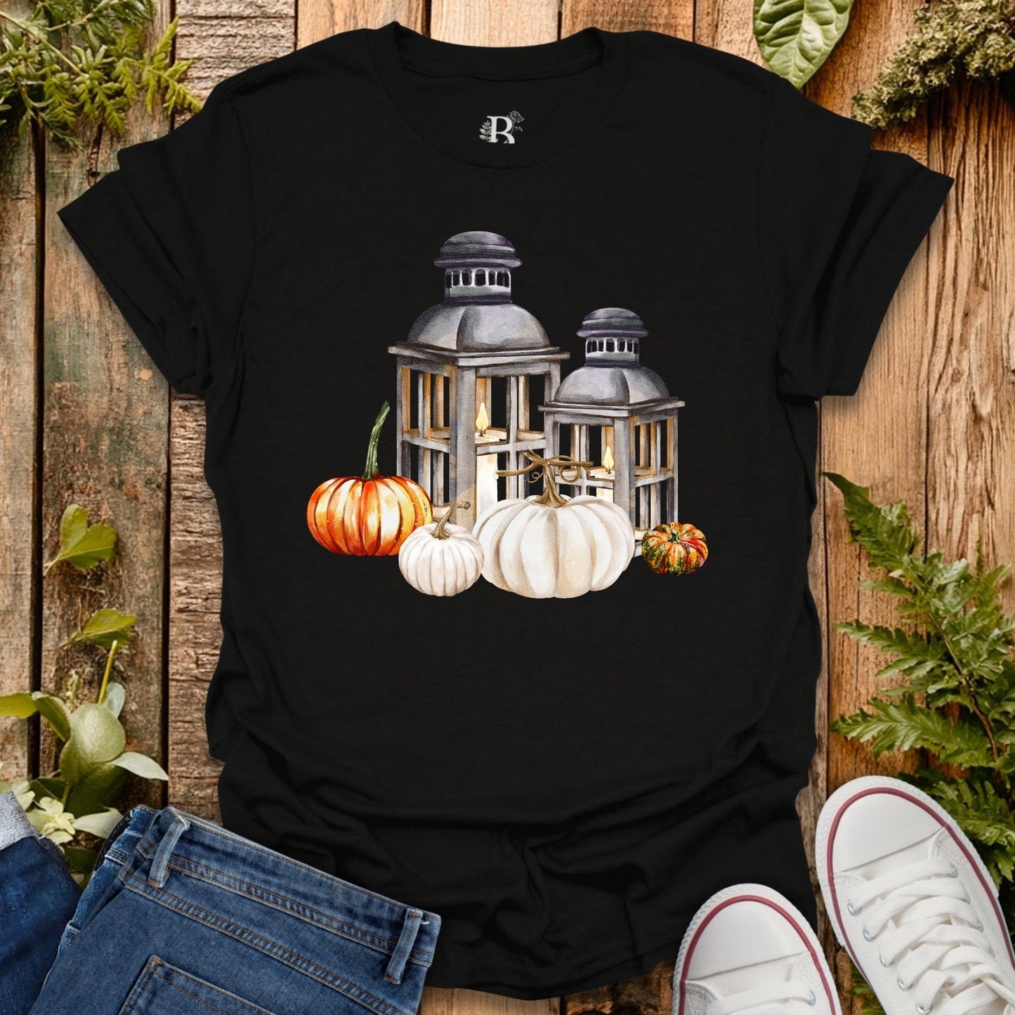 Black t-shirt with lantern and pumpkins design on a wooden background