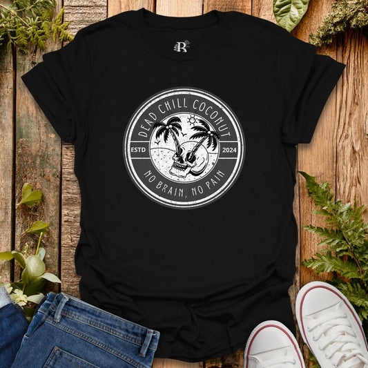 Black t-shirt with a graphic design on a wooden surface with plants.