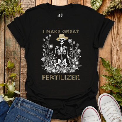 Black t-shirt with skeleton design and text on a wooden surface with plants.