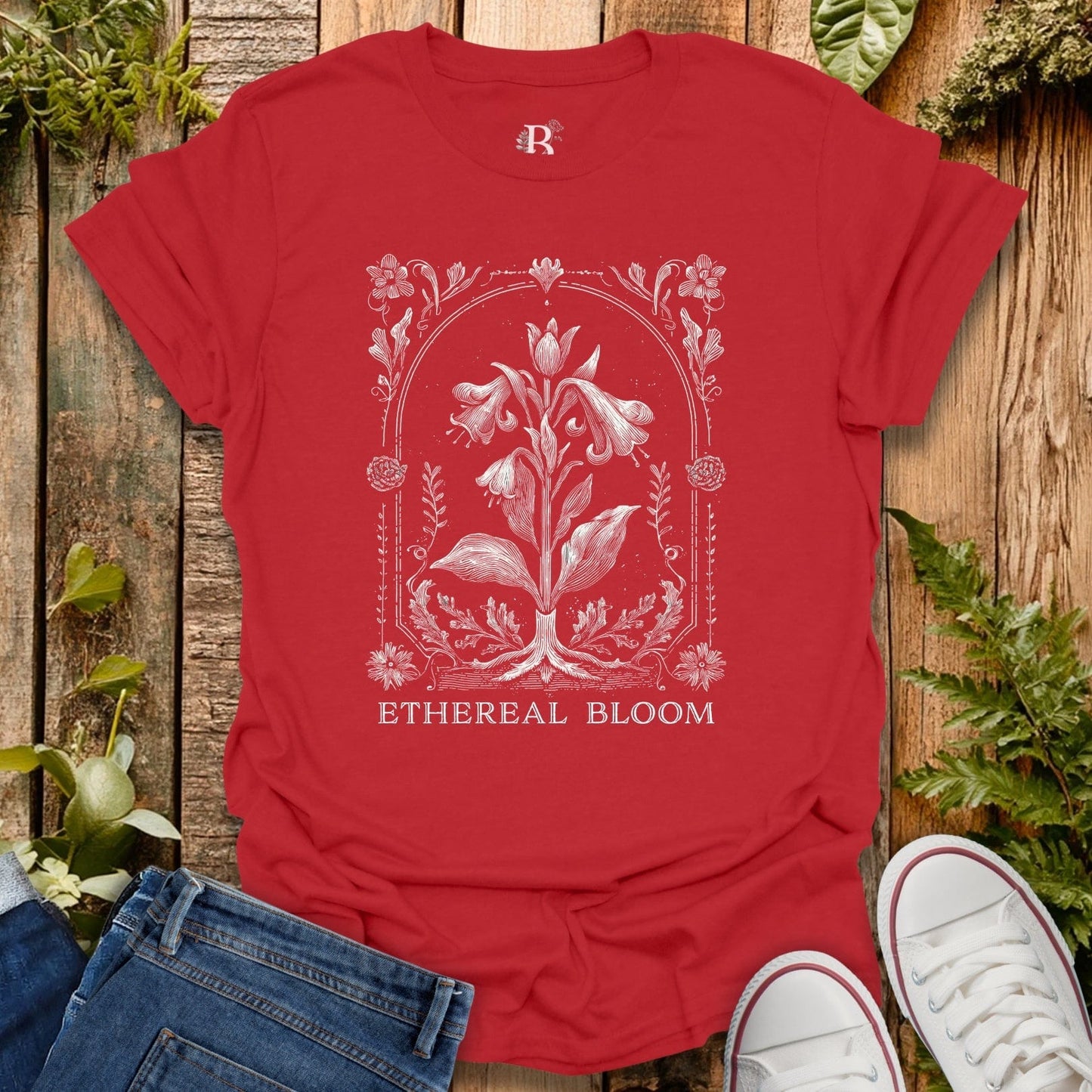 Red t-shirt with floral design and 'Ethereal Bloom' text on a wooden background