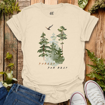 Beige t-shirt with forest design and text on a wooden background