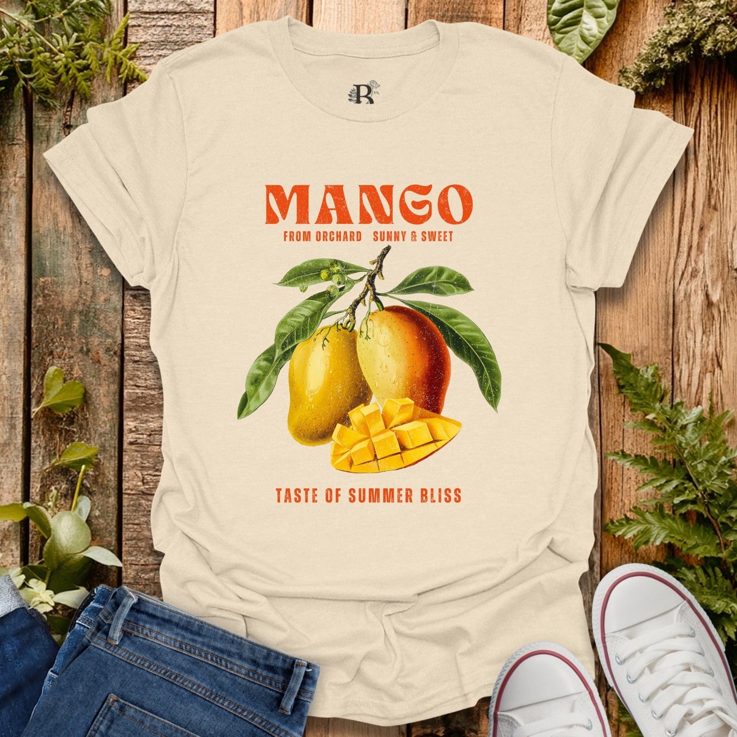Beige t-shirt with mango graphic and text on a wooden background