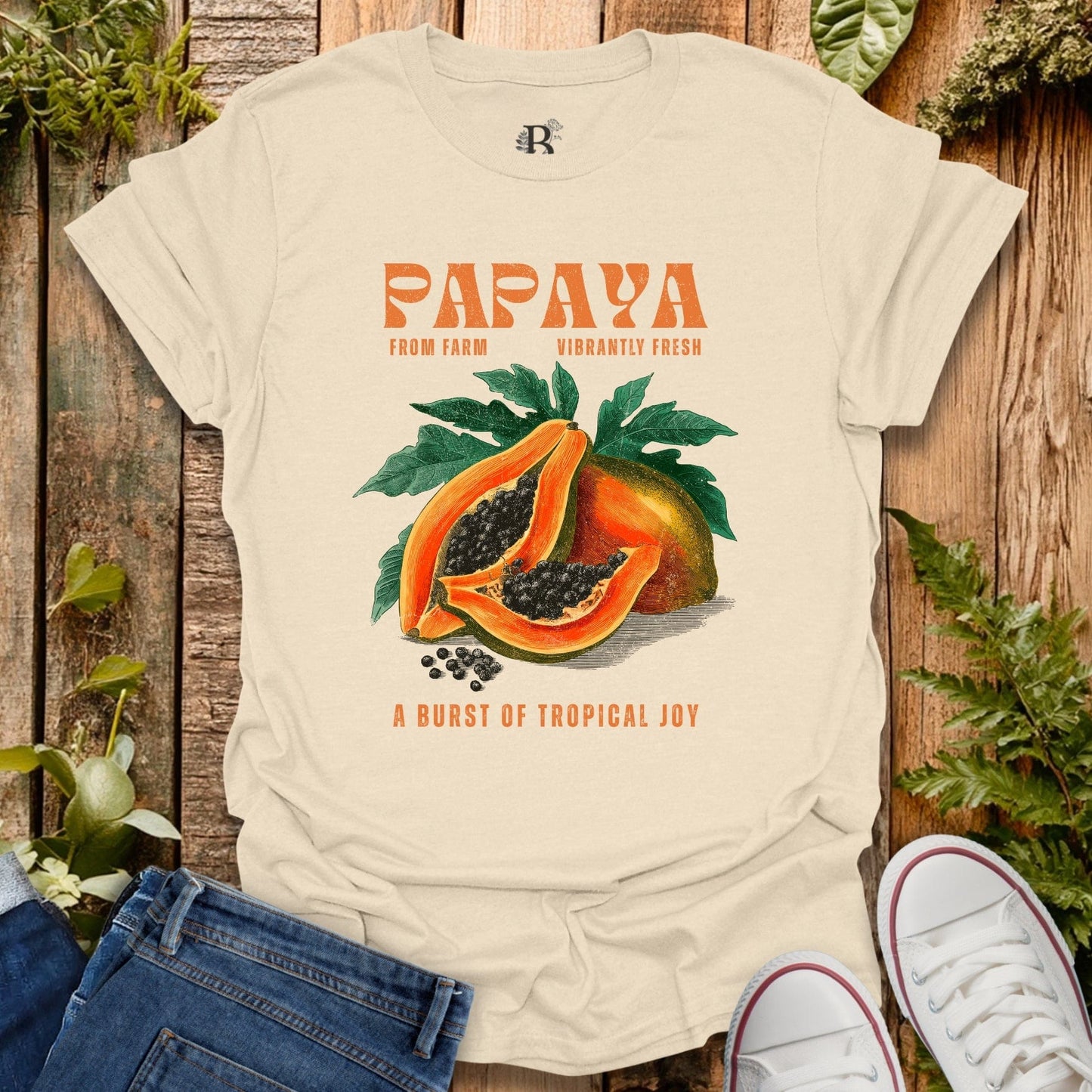 Beige t-shirt with papaya graphic and text on a wooden background