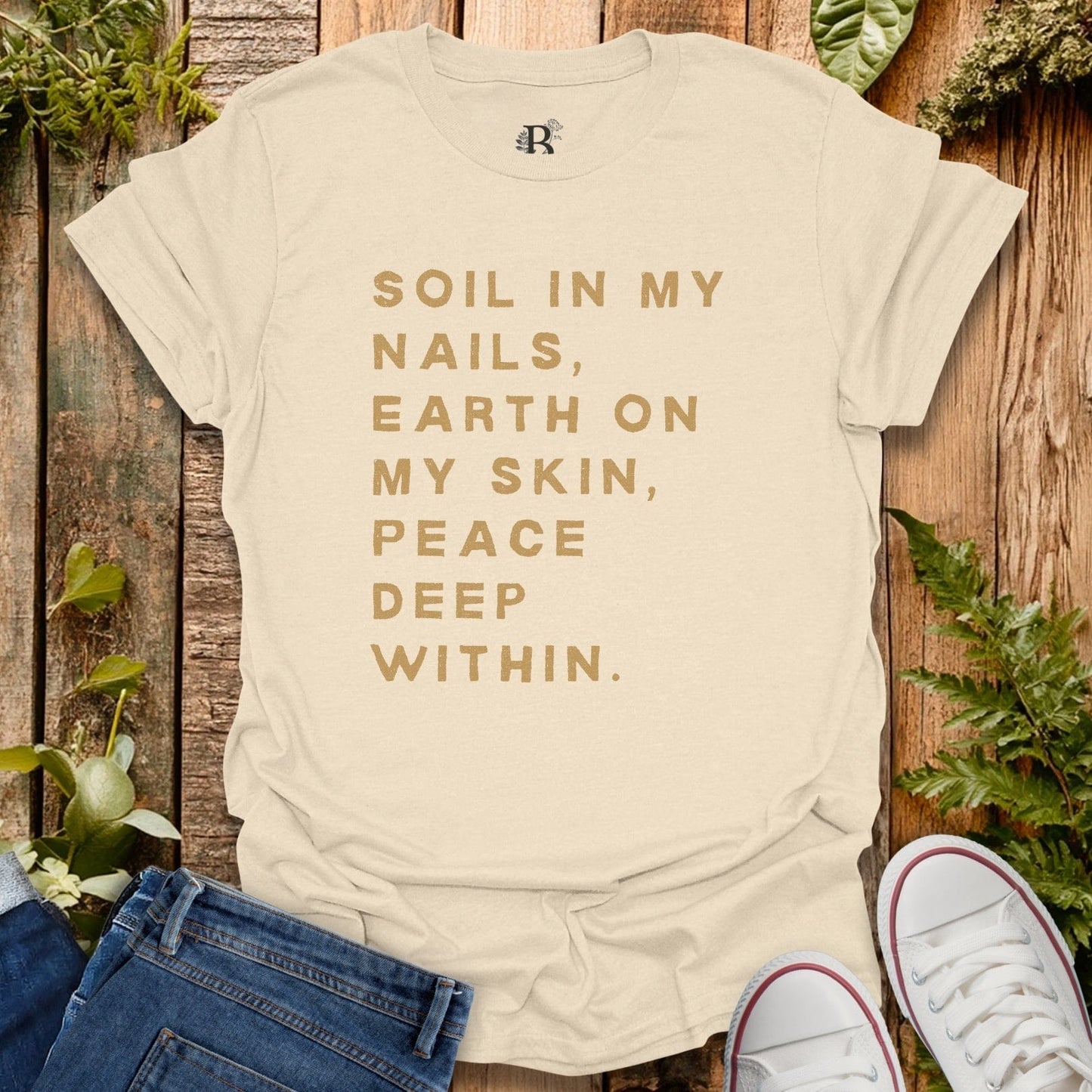 Beige t-shirt with motivational quote on a wooden background with plants