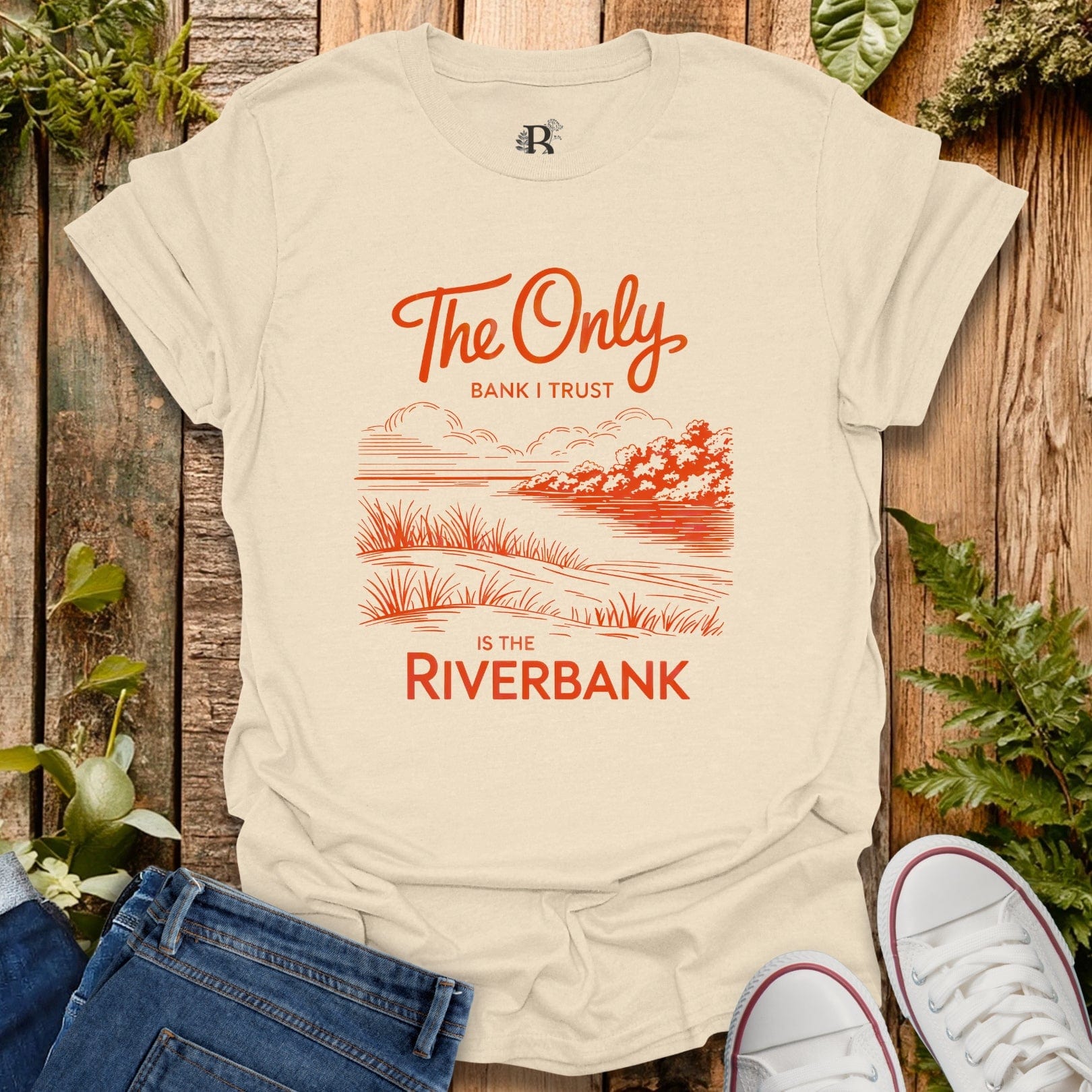 Beige t-shirt with red graphic and text on a wooden background