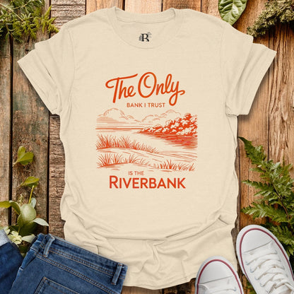 Beige t-shirt with red graphic and text on a wooden background