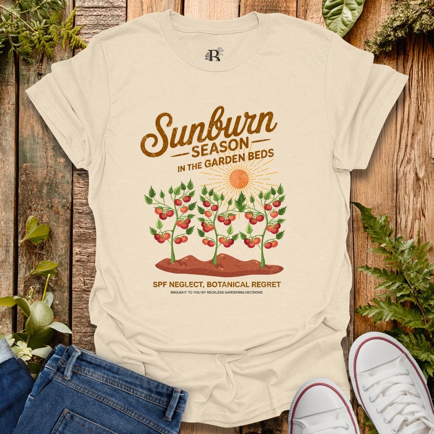 Beige t-shirt with garden-themed graphic and text on a wooden background