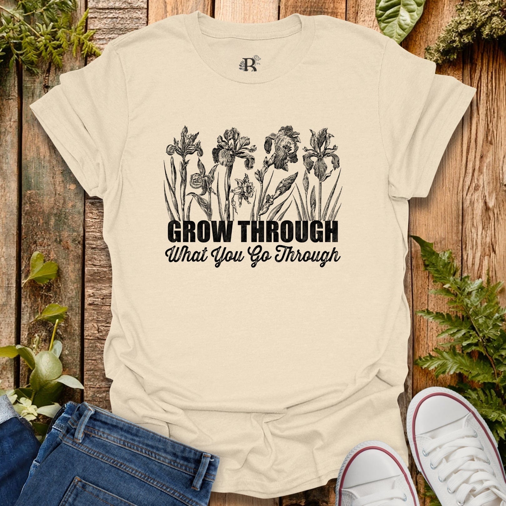 Beige t-shirt with floral design and motivational quote on a wooden background