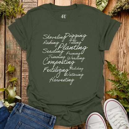 Green t-shirt with gardening-related text on a wooden background with plants.