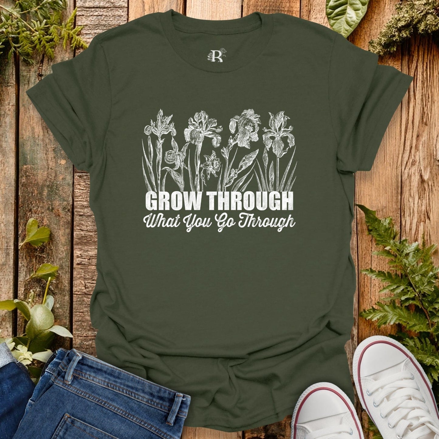 Green t-shirt with floral design and motivational quote on a wooden background