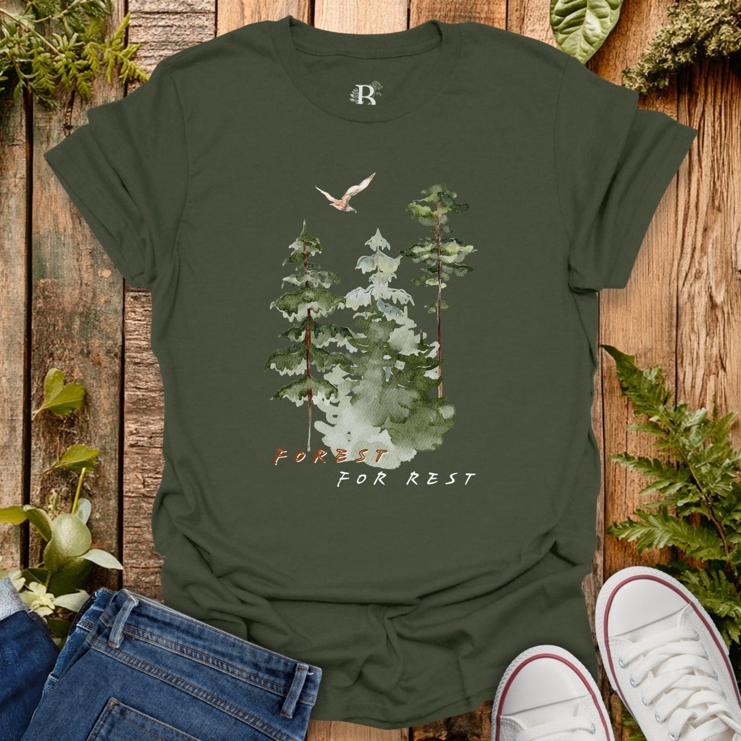 Green t-shirt with forest design and text on a wooden background