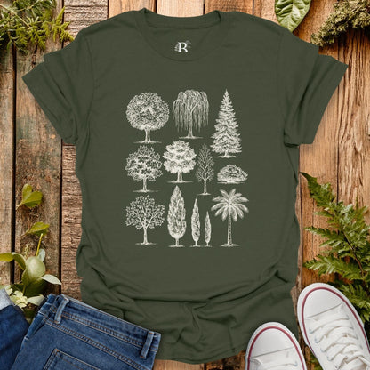 Green t-shirt with tree illustrations on a wooden surface with plants around