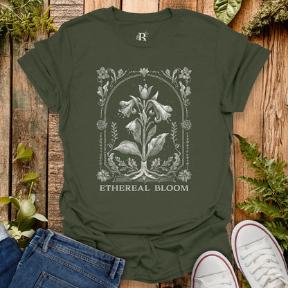 Green t-shirt with floral design and 'Ethereal Bloom' text on a wooden surface with plants.