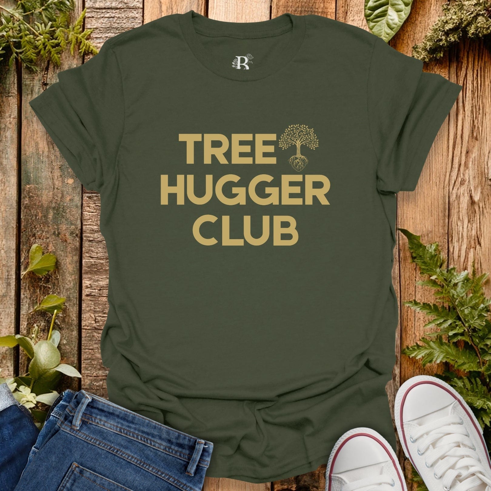 Green t-shirt with 'Tree Hugger Club' text on a wooden background with plants.