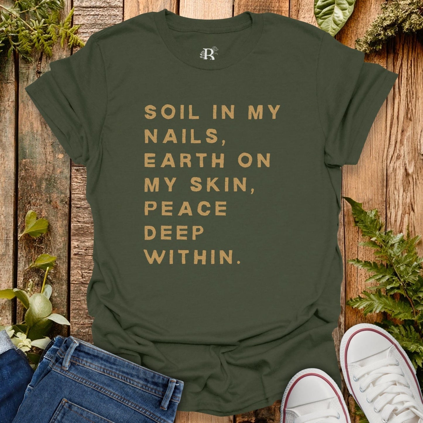 Green t-shirt with text on a wooden background with plants