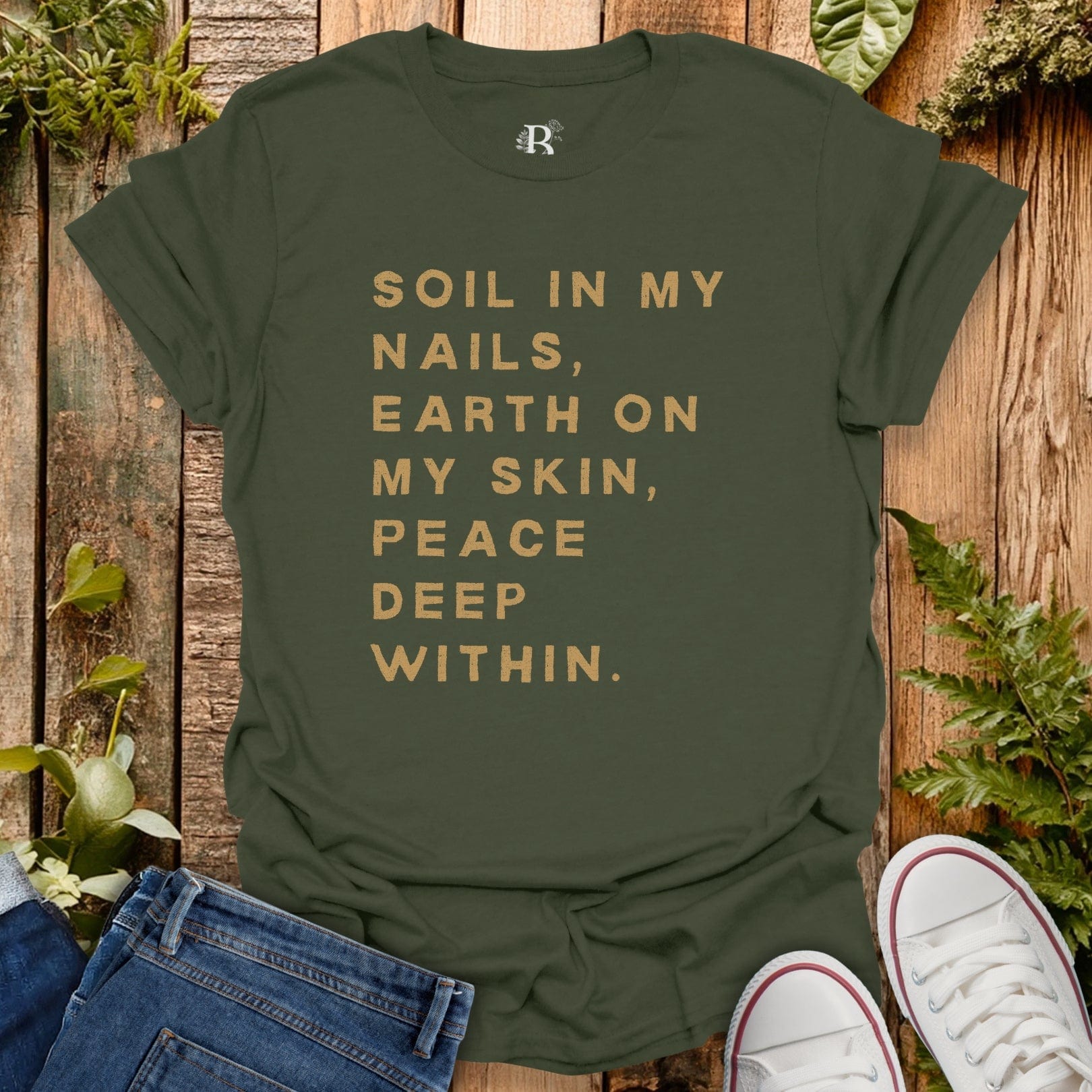 Green t-shirt with text on a wooden background with plants